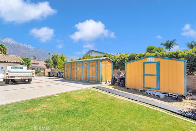 view of yard featuring a mountain view and a storage shed