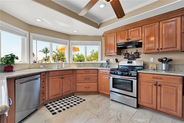 kitchen featuring light stone counters, sink, appliances with stainless steel finishes, crown molding, and ceiling fan