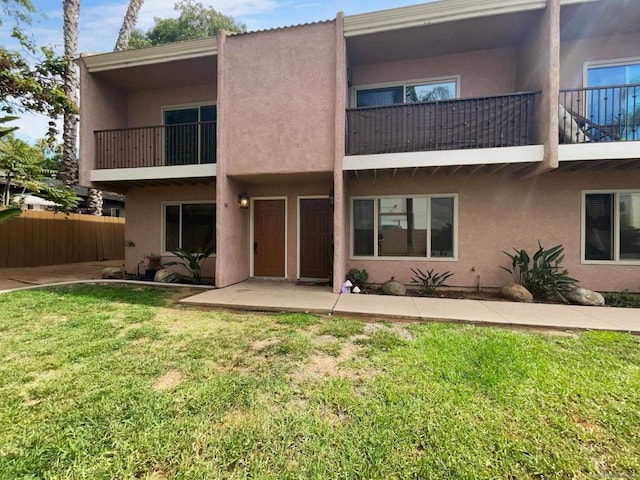 rear view of house featuring a lawn and a patio area