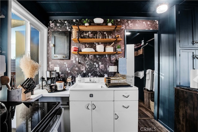 bar with electric range oven, white cabinetry, sink, and dark hardwood / wood-style flooring