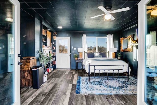 bedroom with ceiling fan, crown molding, and dark hardwood / wood-style flooring