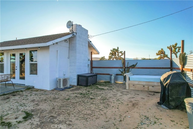 view of side of home featuring french doors and ac unit