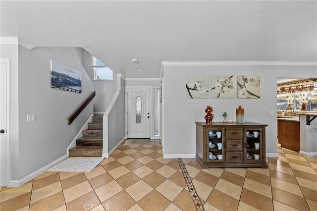 foyer with light tile patterned floors and crown molding