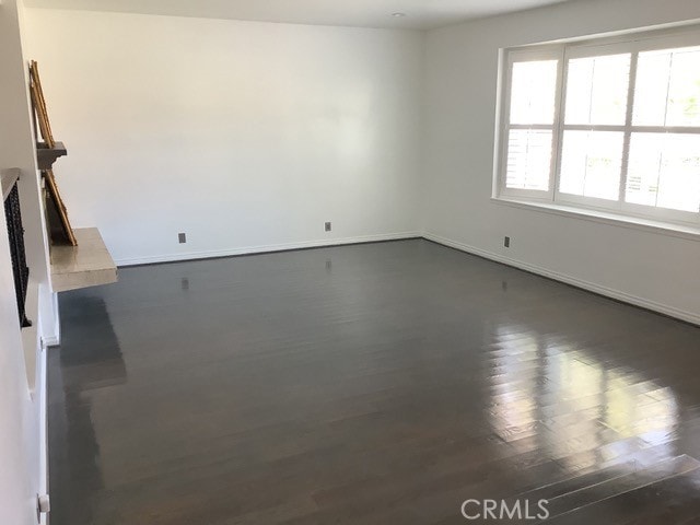 unfurnished living room with dark wood-type flooring