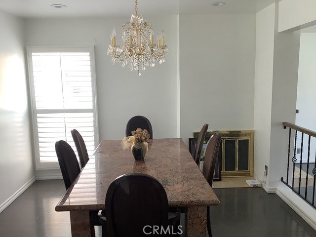 dining area with dark hardwood / wood-style flooring and a notable chandelier