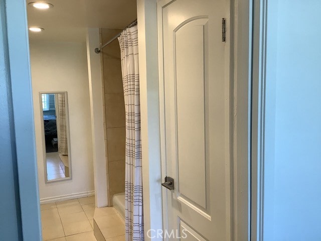 bathroom featuring a shower with curtain, tile patterned floors, and toilet