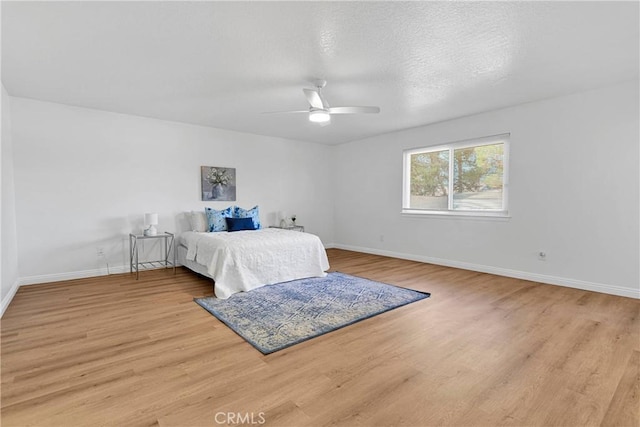 bedroom featuring ceiling fan, a textured ceiling, and light hardwood / wood-style flooring