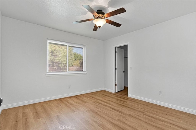 unfurnished room featuring ceiling fan, light hardwood / wood-style flooring, and a textured ceiling