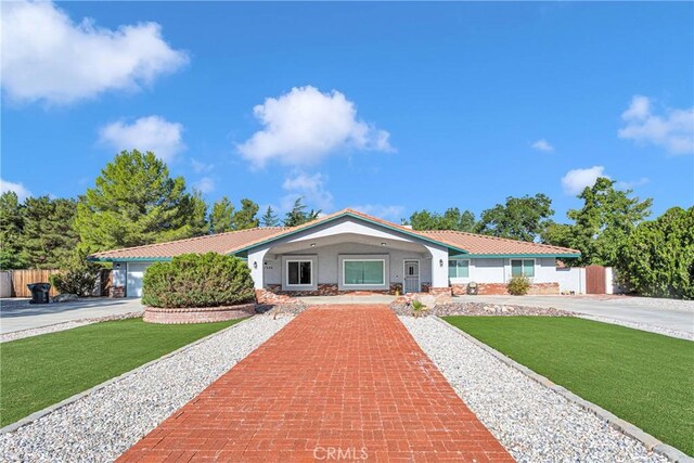 single story home featuring a garage and a front yard