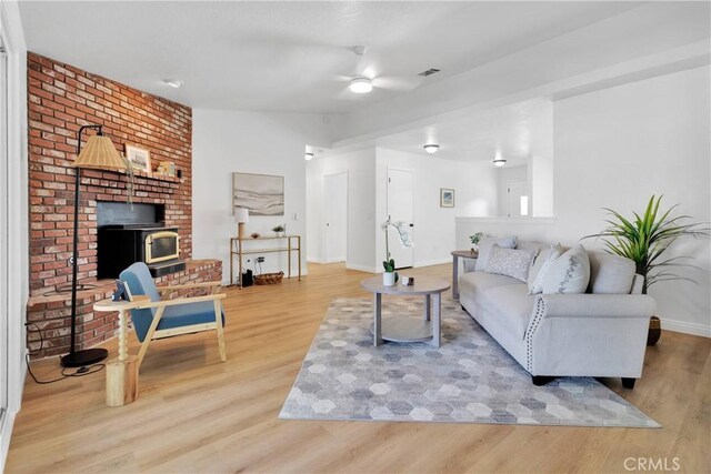 living room featuring a wood stove and light hardwood / wood-style flooring