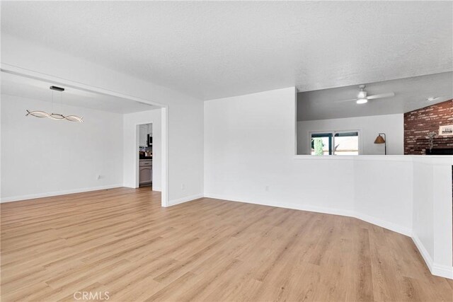 unfurnished room featuring ceiling fan, a textured ceiling, and light wood-type flooring