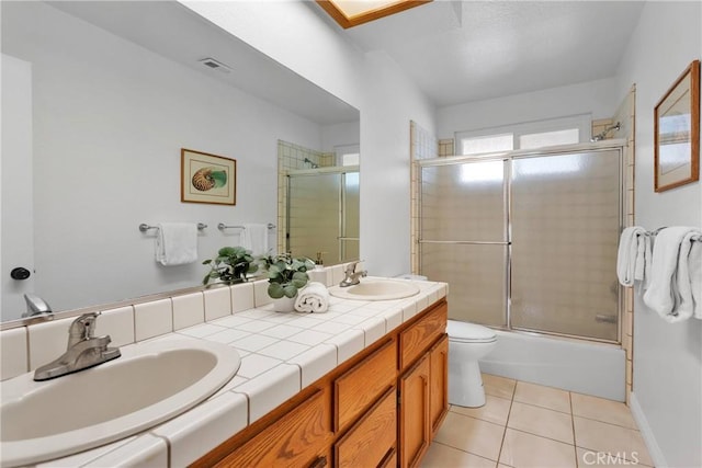 full bathroom with tile patterned flooring, vanity, toilet, and shower / bath combination with glass door