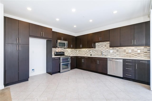 kitchen featuring light tile patterned floors, dark brown cabinetry, appliances with stainless steel finishes, and tasteful backsplash