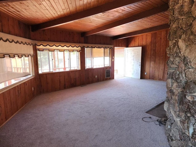 unfurnished room featuring carpet floors, beamed ceiling, wood walls, and wooden ceiling