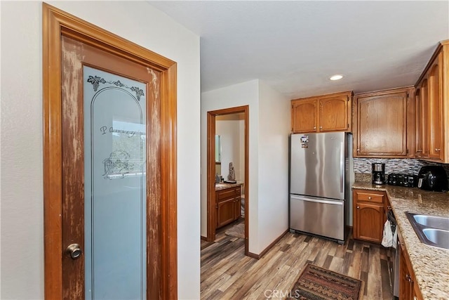 kitchen featuring light hardwood / wood-style floors, appliances with stainless steel finishes, and tasteful backsplash