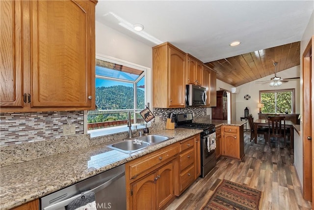 kitchen with ceiling fan, sink, stainless steel appliances, dark hardwood / wood-style flooring, and vaulted ceiling