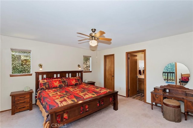 bedroom featuring ceiling fan, light carpet, and connected bathroom