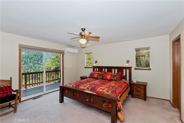 bedroom with ceiling fan, access to exterior, light carpet, and a wall unit AC