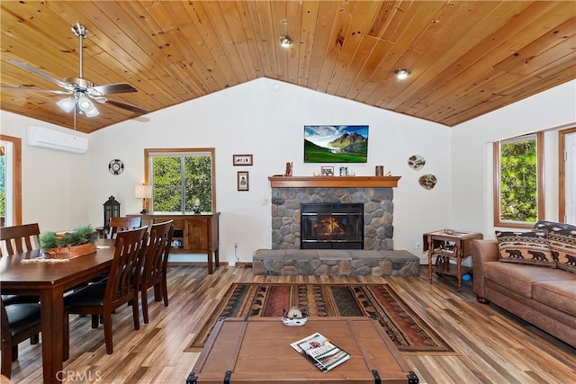 living room featuring a wall mounted air conditioner, a fireplace, hardwood / wood-style floors, and a wealth of natural light