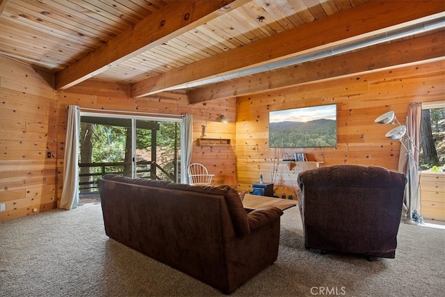 carpeted living room with beamed ceiling, wooden walls, and wood ceiling