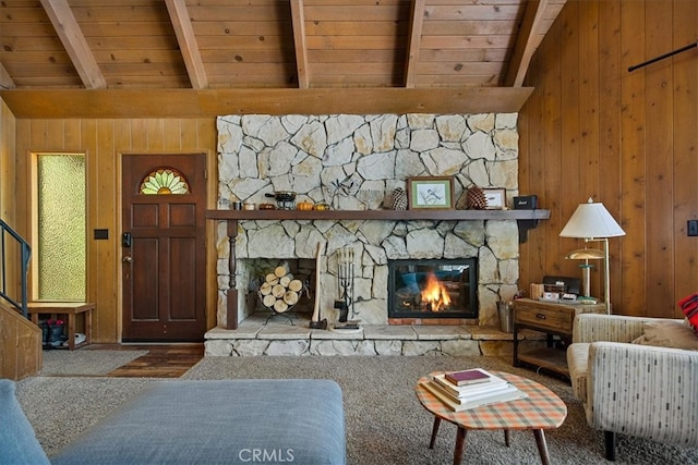 living room featuring beam ceiling, a fireplace, and wood walls