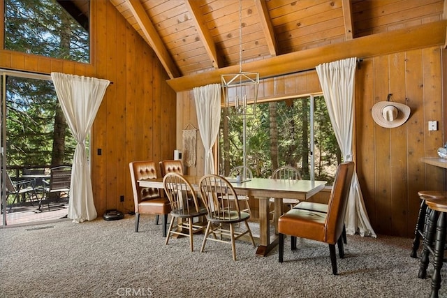 dining area featuring wood ceiling, wood walls, carpet floors, and vaulted ceiling with beams