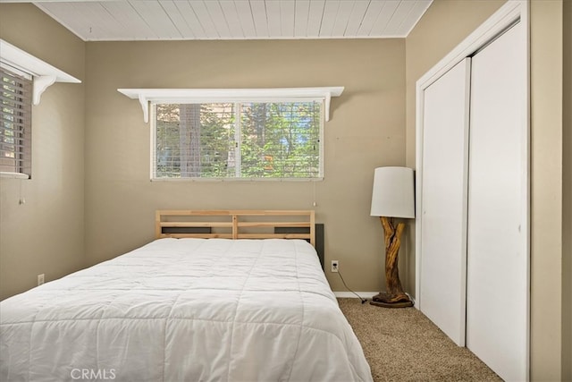 bedroom featuring a closet, carpet flooring, and wooden ceiling