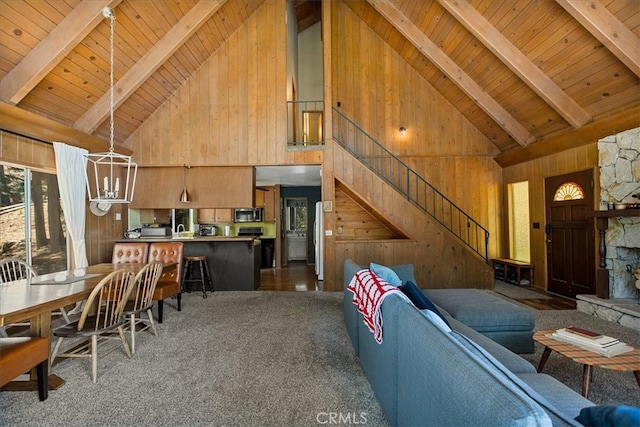 carpeted living room with wood walls, beamed ceiling, high vaulted ceiling, and wooden ceiling