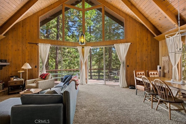 living room featuring wooden walls, wood ceiling, carpet floors, and high vaulted ceiling