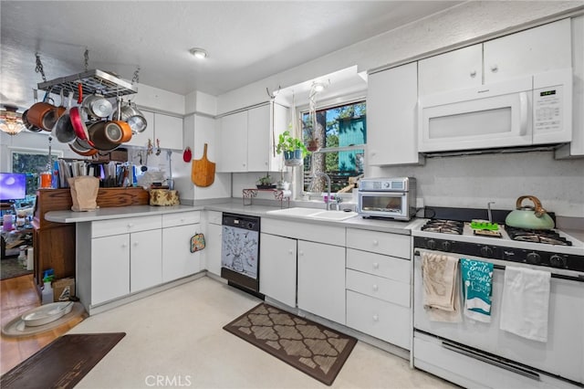 kitchen featuring white appliances, white cabinetry, and sink