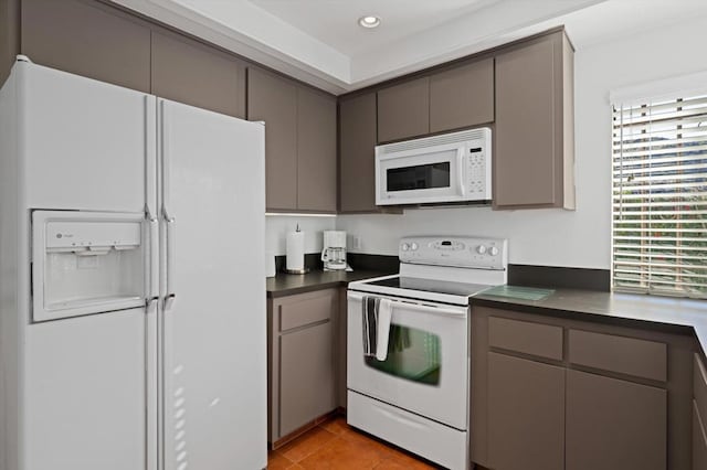 kitchen with gray cabinets, white appliances, and light tile patterned flooring