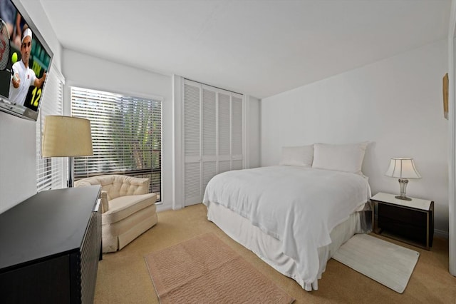 bedroom featuring light carpet and a closet