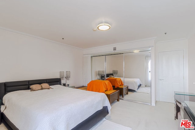 bedroom featuring a closet, light colored carpet, and ornamental molding