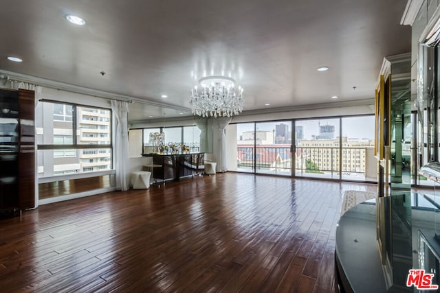 interior space featuring plenty of natural light, dark wood-type flooring, crown molding, and a chandelier