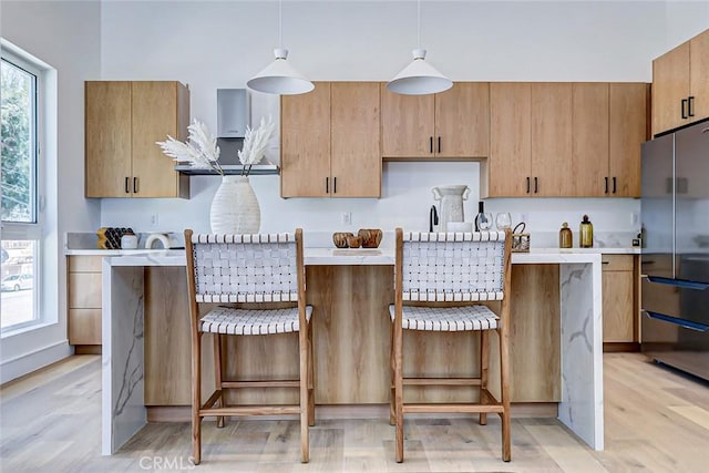 2304 Grant Ave Unit A, Redondo Beach, CA 90278 - kitchen with freestanding refrigerator, light countertops, light wood-style flooring, a center island, and hanging light fixtures