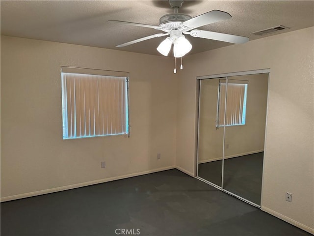 unfurnished bedroom with ceiling fan, a closet, and a textured ceiling