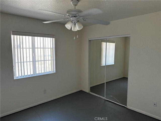 unfurnished bedroom with a textured ceiling, a closet, and ceiling fan