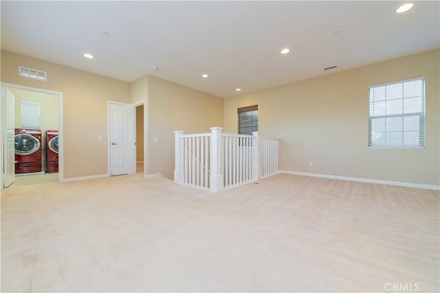 carpeted empty room featuring washing machine and dryer