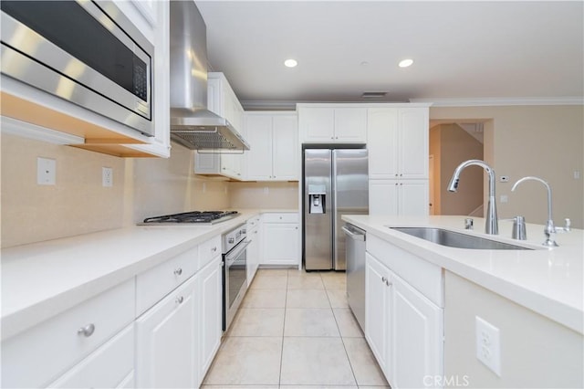 kitchen with light tile patterned flooring, sink, white cabinetry, appliances with stainless steel finishes, and wall chimney range hood