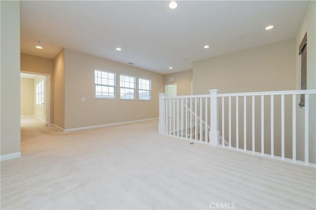 spare room featuring light colored carpet