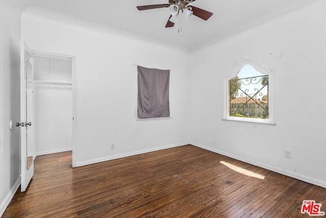 unfurnished bedroom with a closet, ceiling fan, and dark hardwood / wood-style flooring