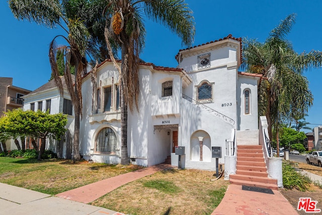 mediterranean / spanish-style house with a front yard