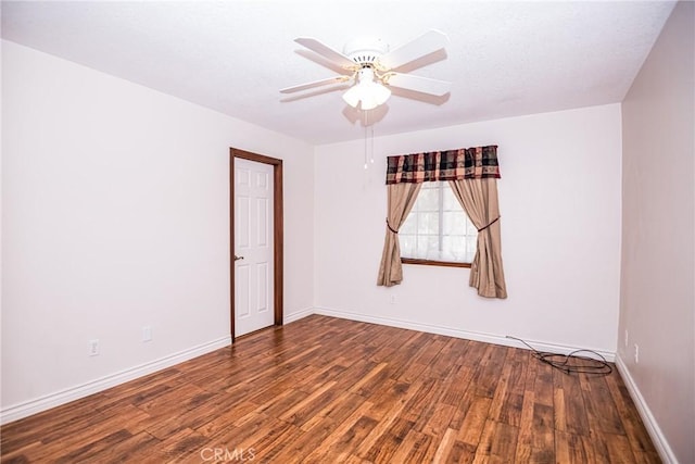 unfurnished room featuring ceiling fan and dark wood-type flooring