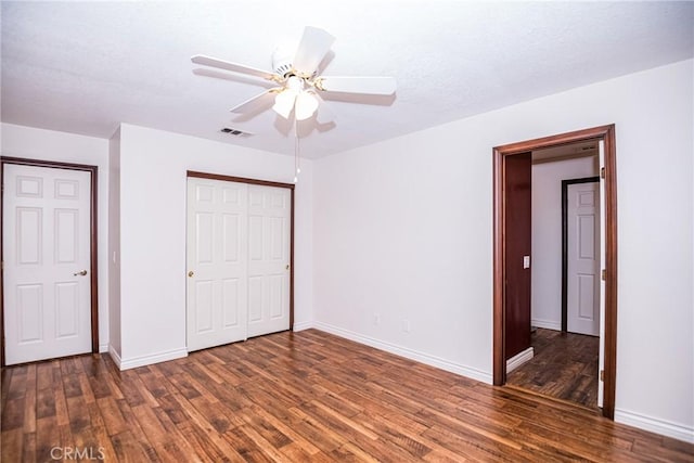 unfurnished bedroom featuring ceiling fan and dark wood-type flooring