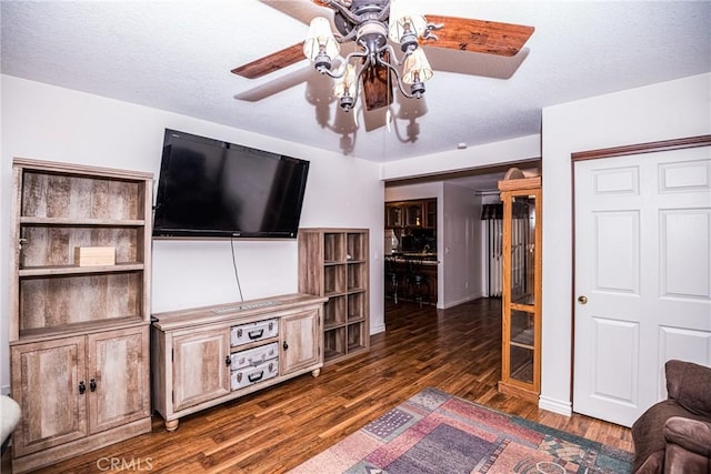 unfurnished living room featuring ceiling fan and dark hardwood / wood-style floors