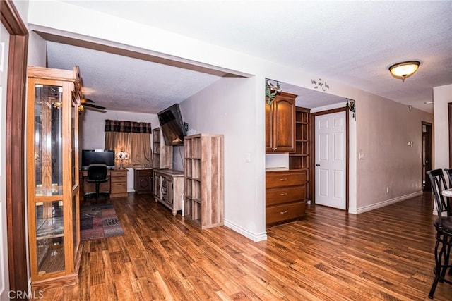 interior space with dark hardwood / wood-style flooring, built in desk, and a textured ceiling