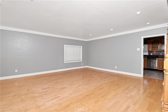 spare room featuring light wood-type flooring and ornamental molding