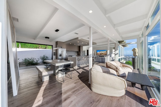 living room featuring light hardwood / wood-style flooring and beamed ceiling