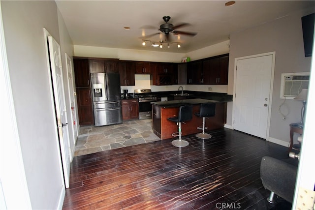 kitchen with dark hardwood / wood-style floors, sink, a kitchen breakfast bar, appliances with stainless steel finishes, and a wall mounted AC