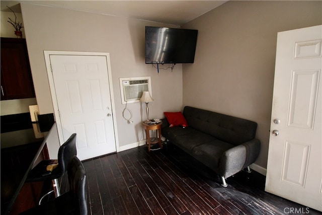 living area featuring an AC wall unit and dark hardwood / wood-style floors